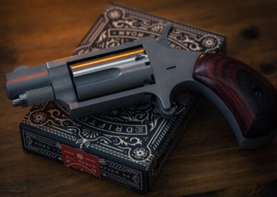 silver and brown revolver pistol on black and white book